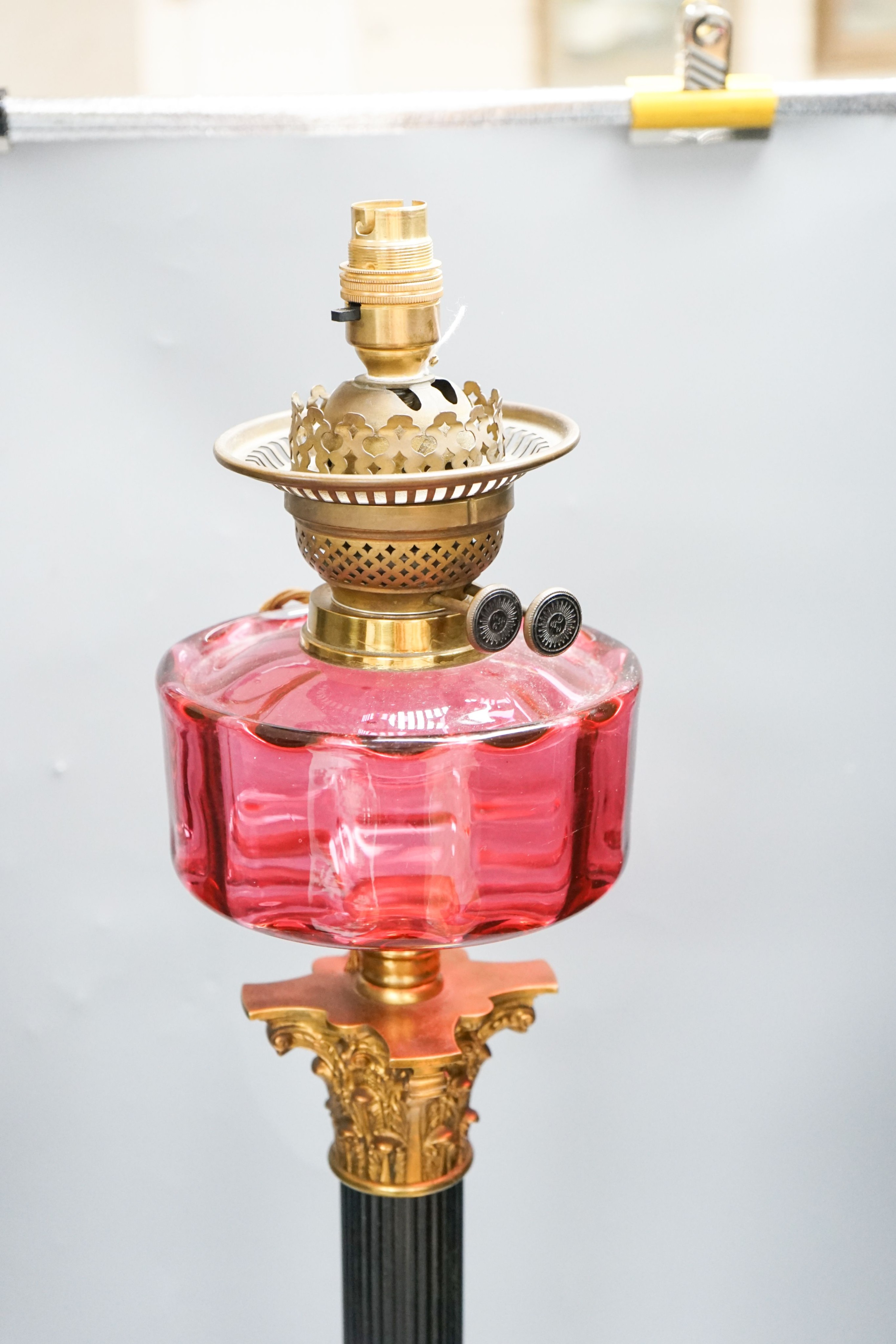 And early 20th century Corinthian column brass and cranberry glass oil lamp, converted for electricity, total height 70 cm